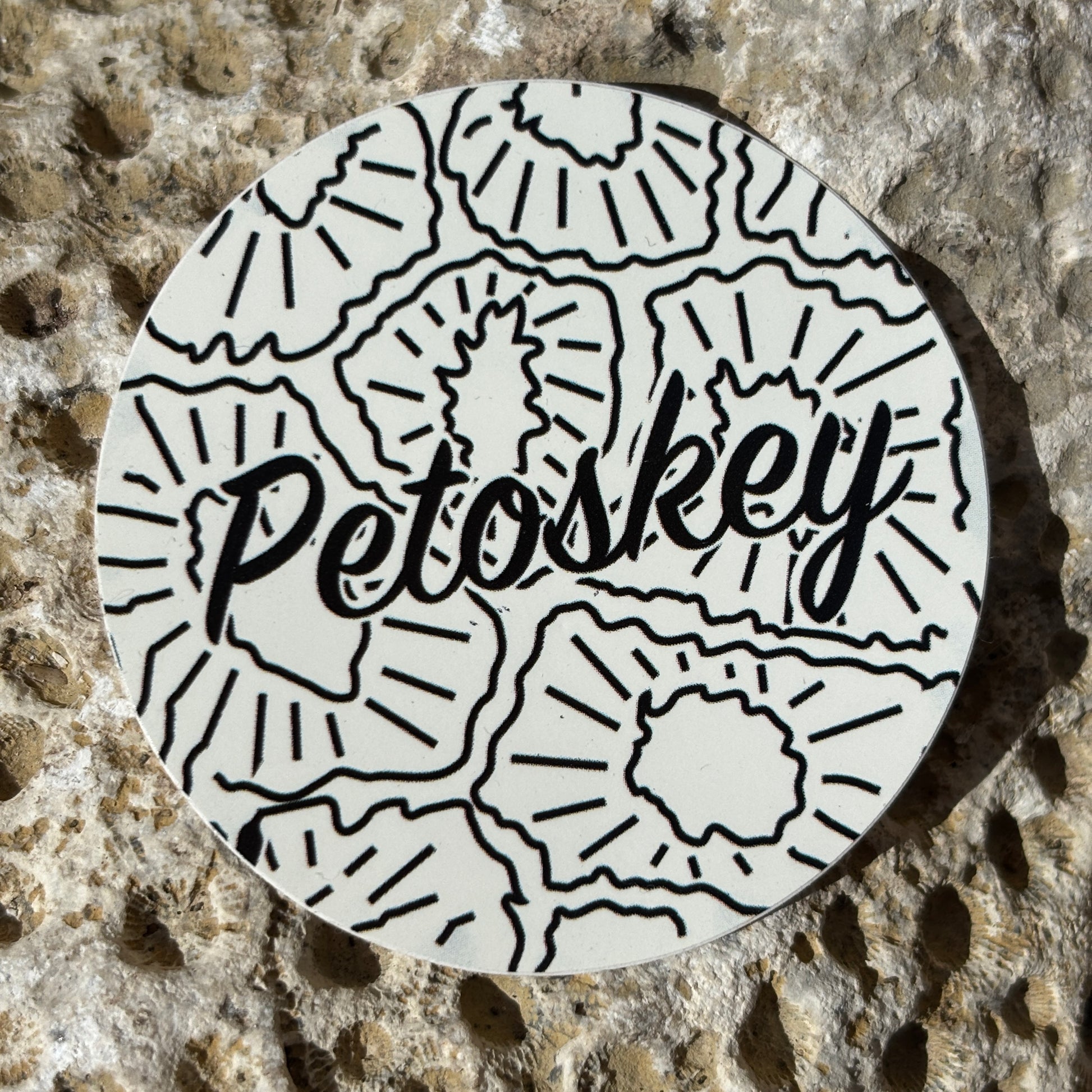Circular sticker with 'Petoskey' text on a textured stone background