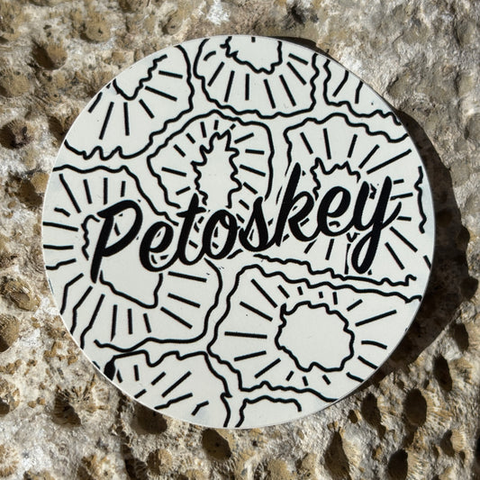 Circular sticker with 'Petoskey' text on a textured stone background