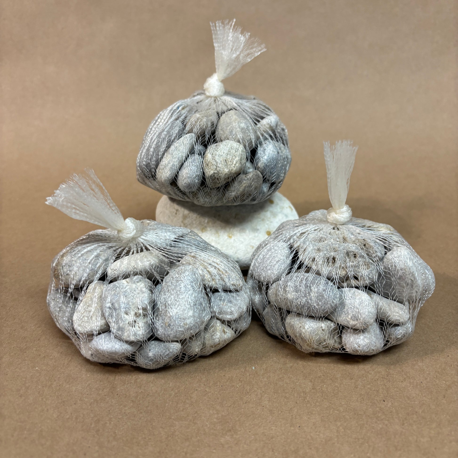 Three bags of petoskey stones on a brown background