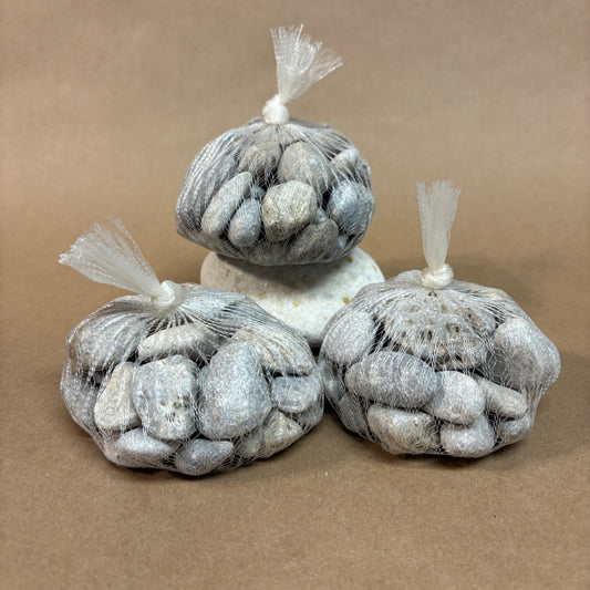 Three bags of petoskey stones on a brown background