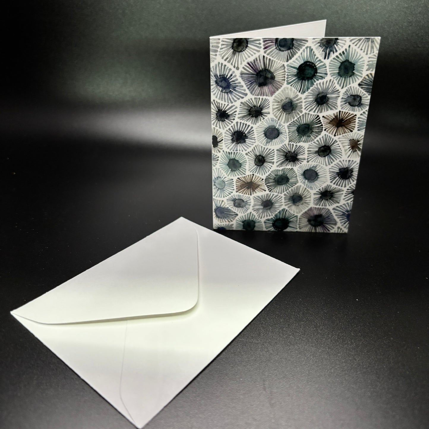 Greeting card with coral pattern and matching envelope on a dark background