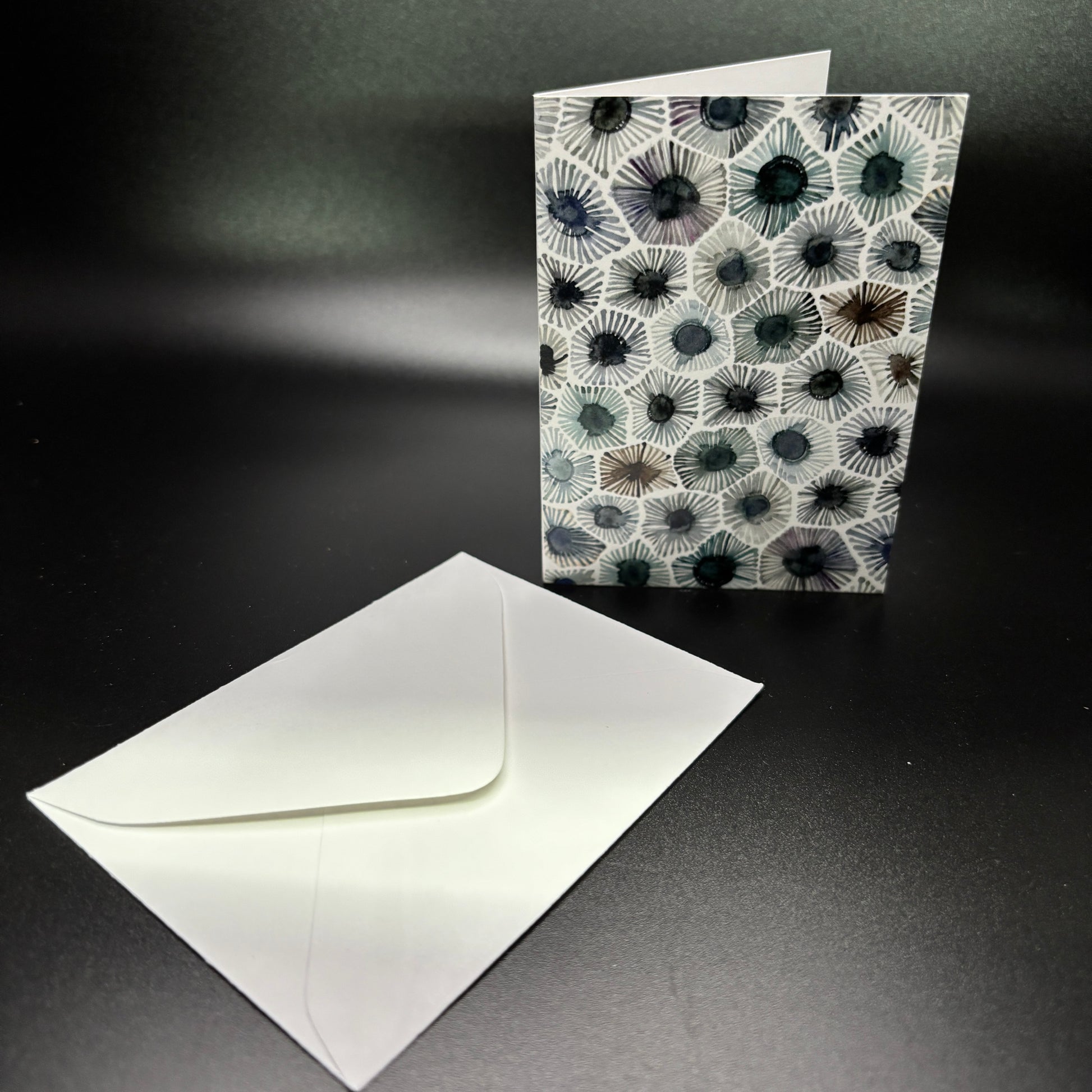 Greeting card with coral pattern and matching envelope on a dark background