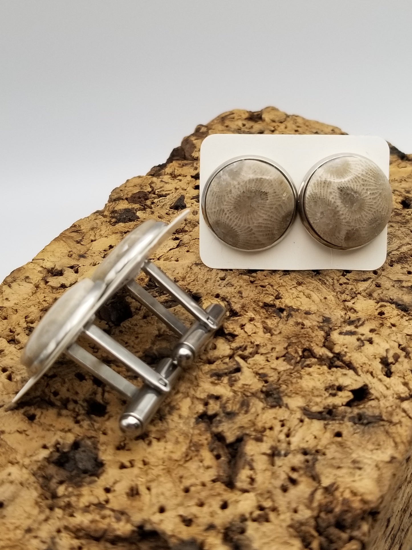 Two sets of petoskey stone set stainless steel cufflinks. One is a side view and the other is a facing forward view. 