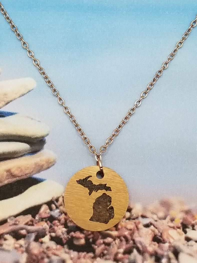 Round, gold, pendant necklace with inlay of the state of Michigan filled with sand from all five of the Great Lakes. Perfect souvenir for all ages.