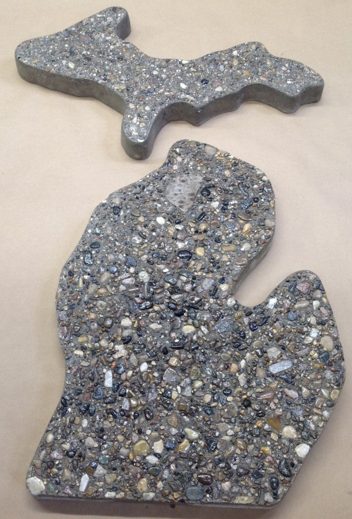 Image of a large 2 piece stepping stone set of upper and lower peninsula michigan. Stepping stone set is made from concrete and local Michigan stones. A medium sized flat petoskey stone is set in the upper north west of the lower peninsula. Perfect for any garden or walkway.